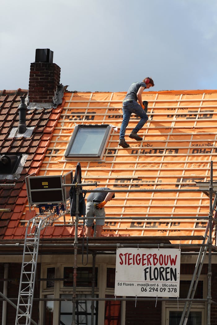 About Construction workers installing new roof tiles in the Netherlands.